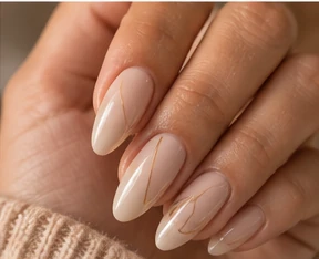 Long almond nails in a creamy nude with fine gold line art